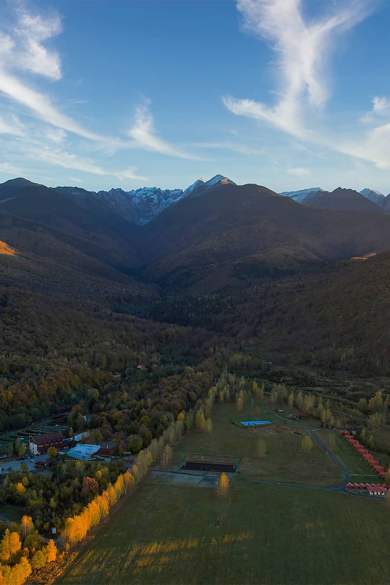 Aerial view of the Albota valley below the snow-capped Făgăraș peaks