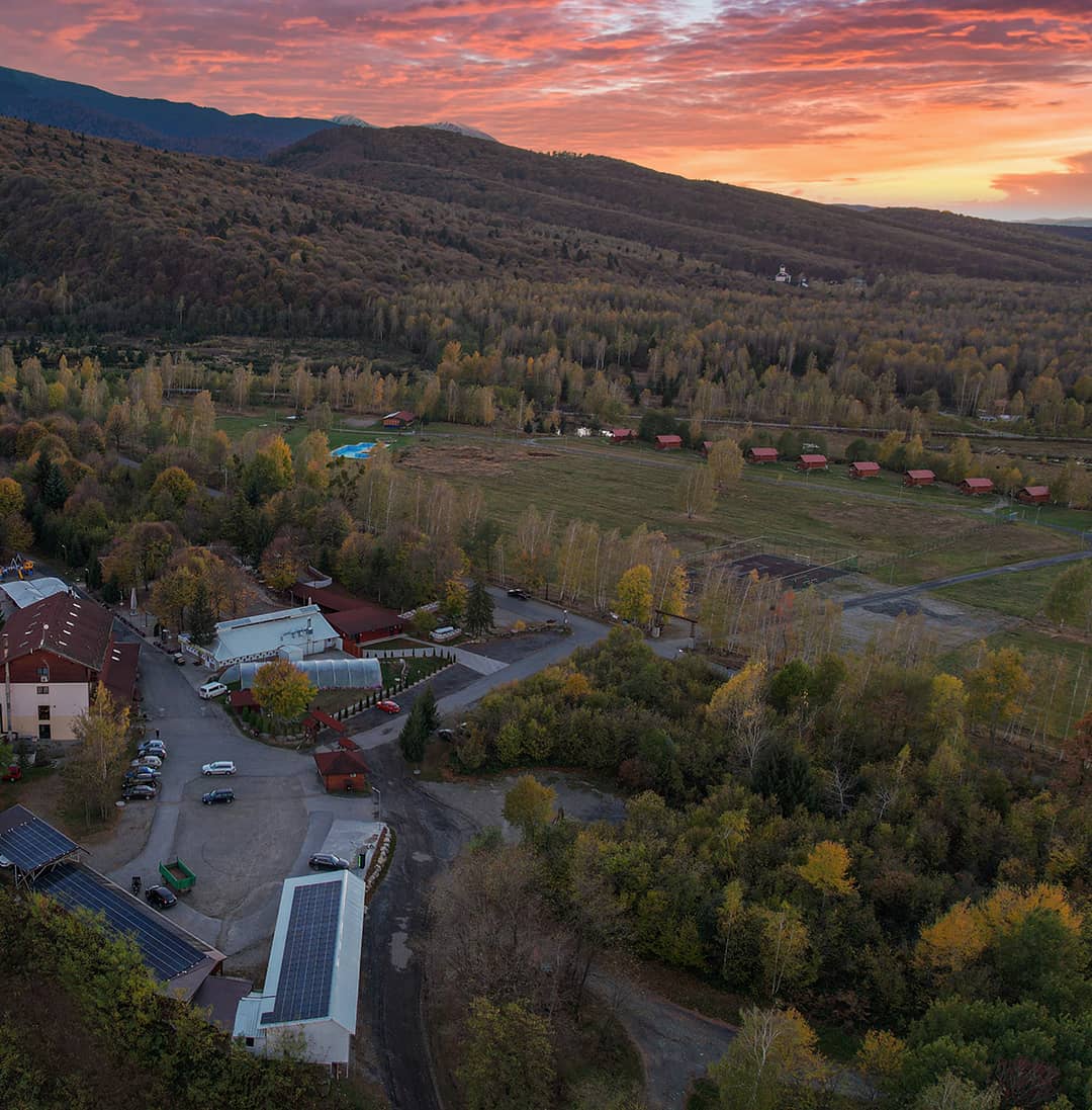 Aerial view of Complex Albota at sunset, with cabins and pool