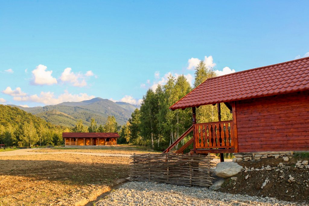 A wooden holiday cabin, with veranda and carved railing