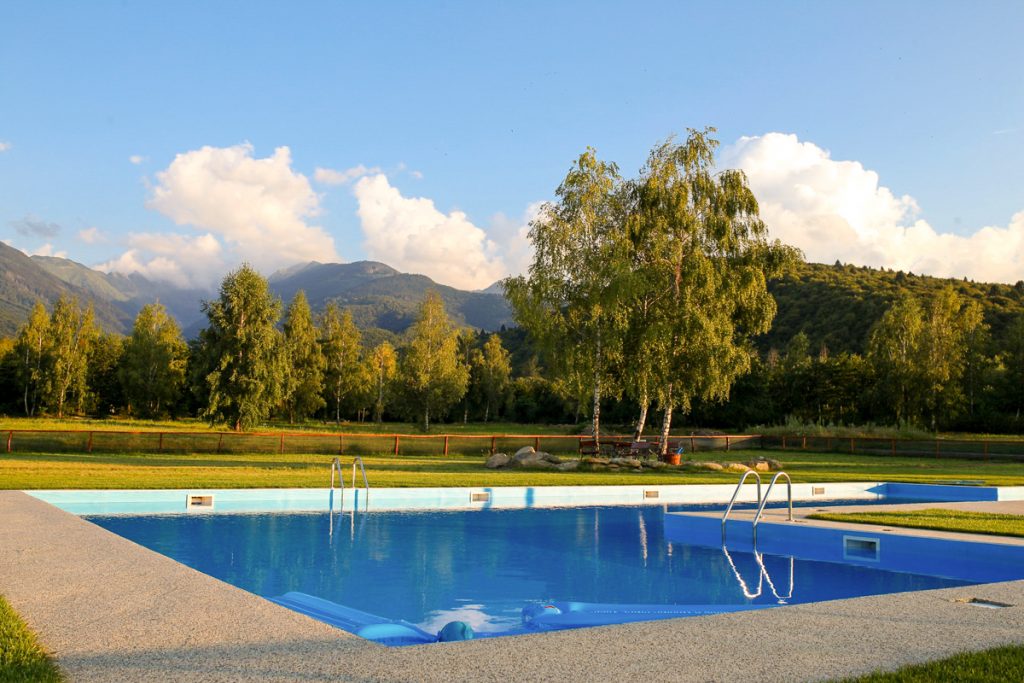 The outdoor pool, with mown lawn and the mountains behind