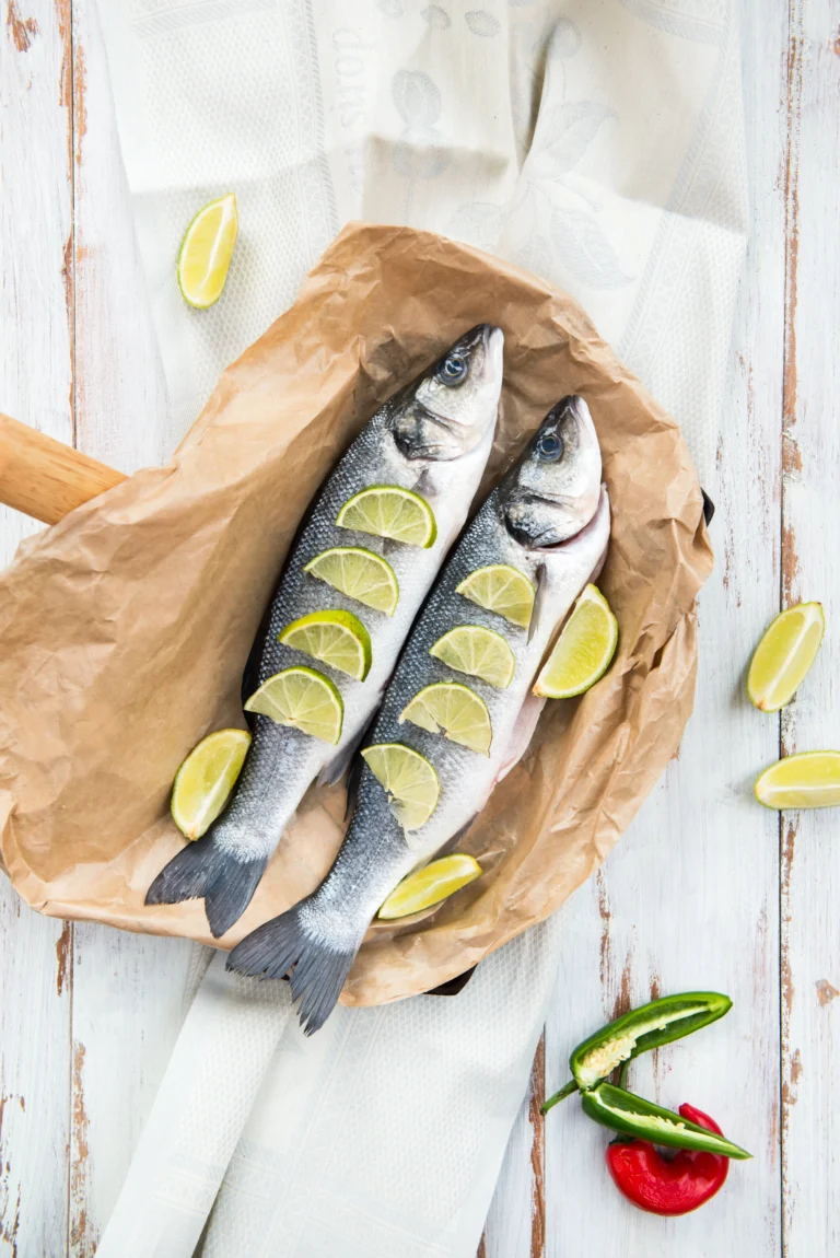 Zwei ganze Fische mit Limettenscheiben, fertig für den Ofen