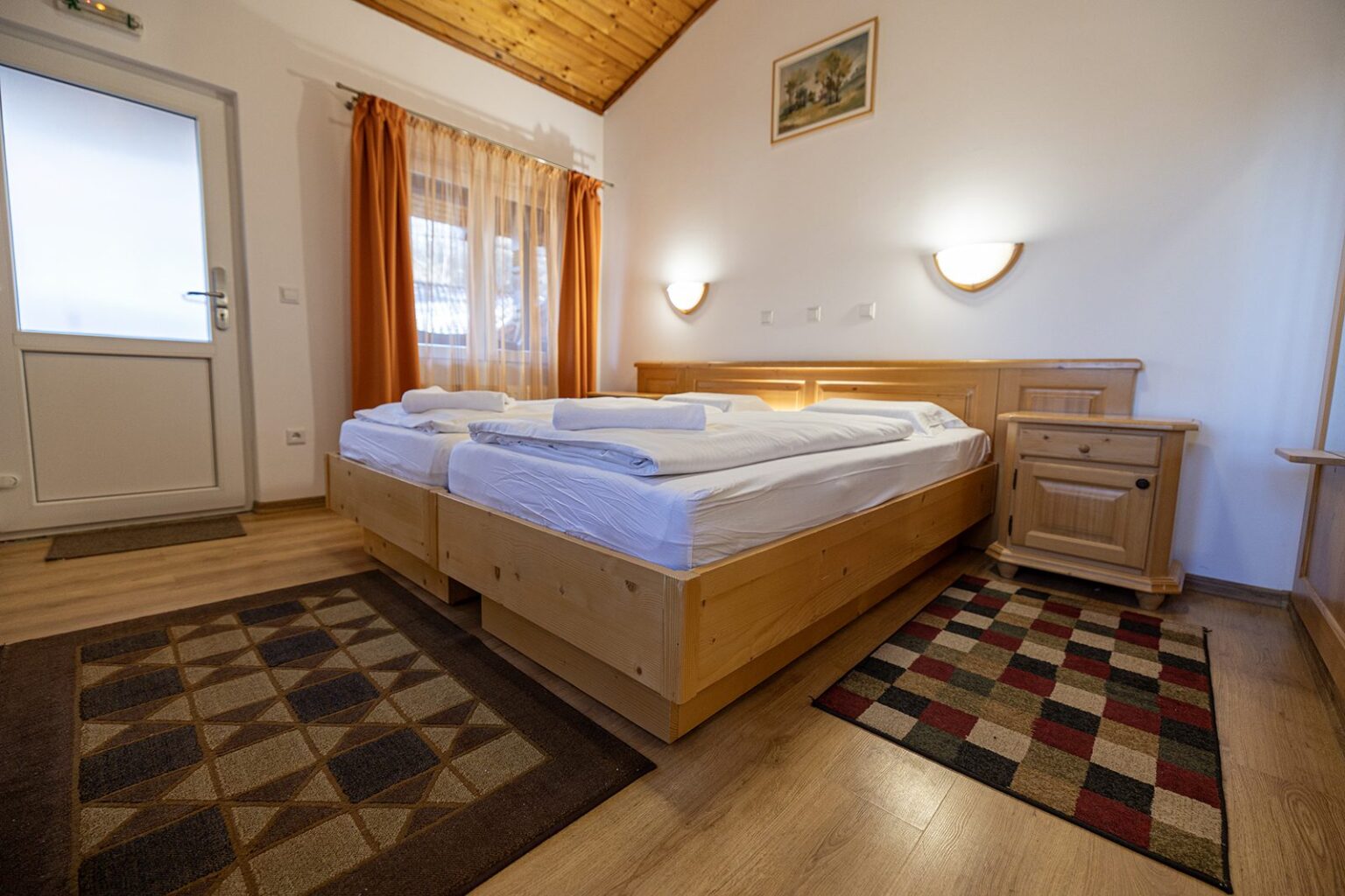Hütte B: Doppelbett, Nachttische und Eingangstür