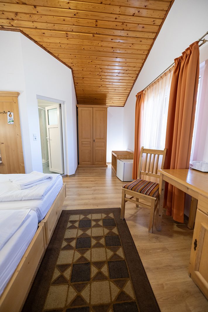 Hütte B: Holzdecke, Bett und Schreibtisch am Fenster