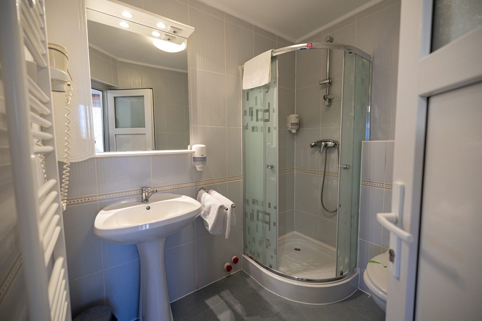 Das Bad der Hütte B mit Eckdusche und Waschbecken