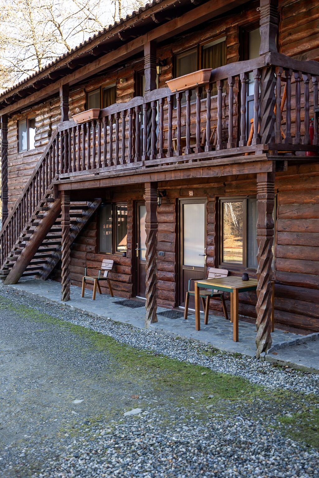 Die Holzhütten von außen, mit Treppe und Balkon im Obergeschoss