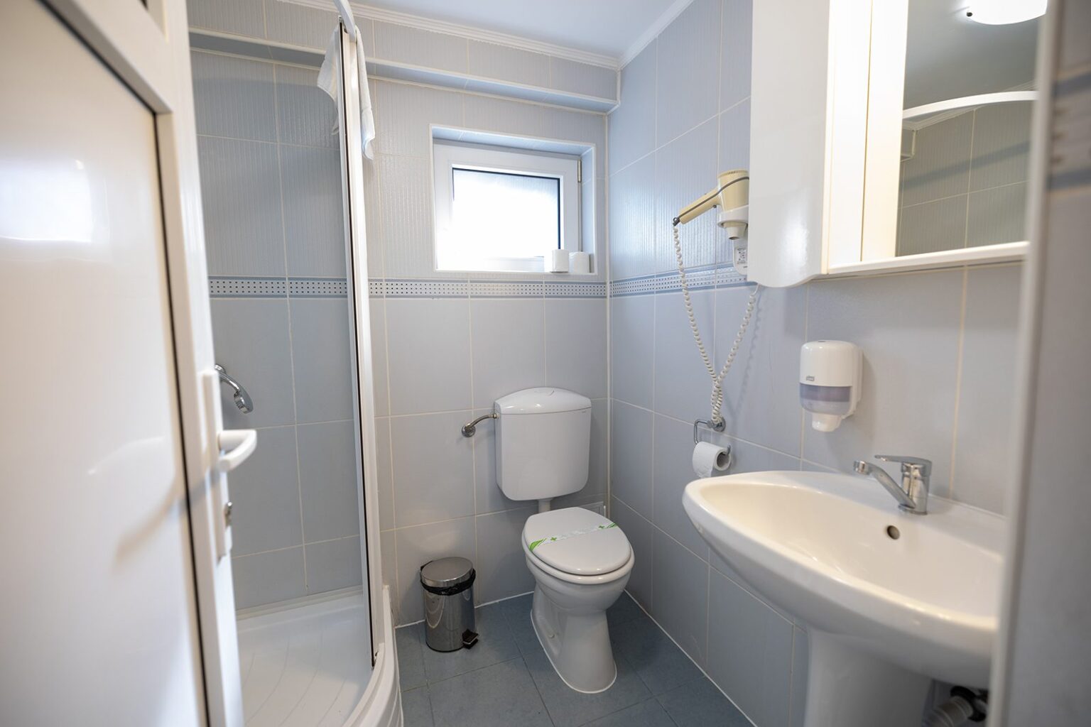 Das Bad der Hütte C mit Dusche und Waschbecken