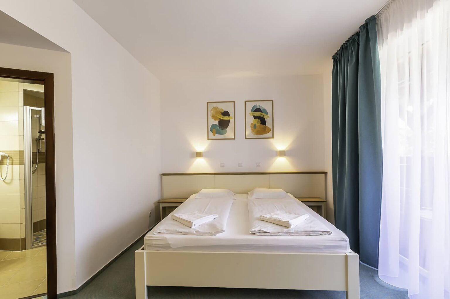 Das Doppelbett mit Wandleuchten neben dem Fenster zum Balkon