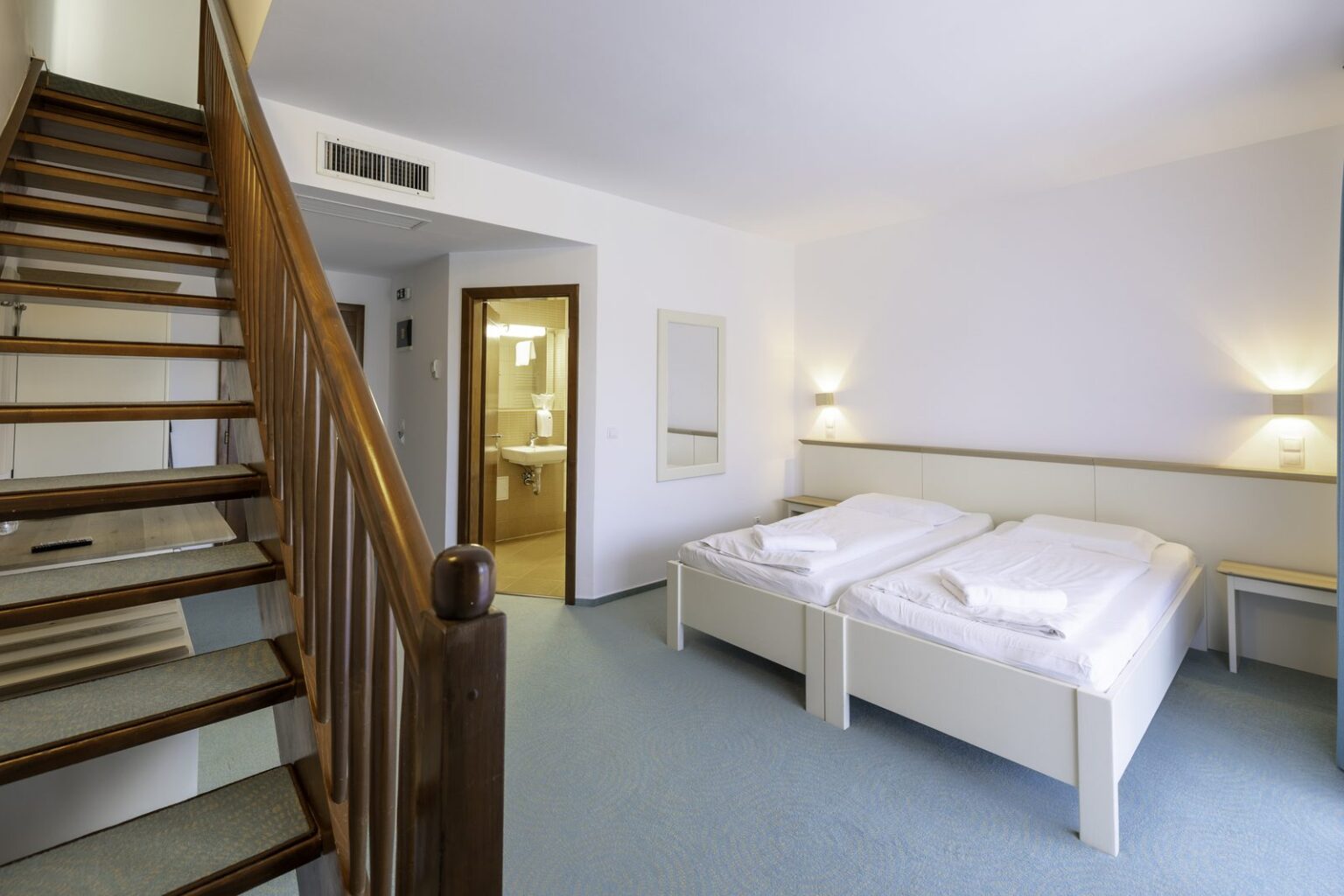 Junior Suite: die Treppe zur Galerie und die zwei Betten unten