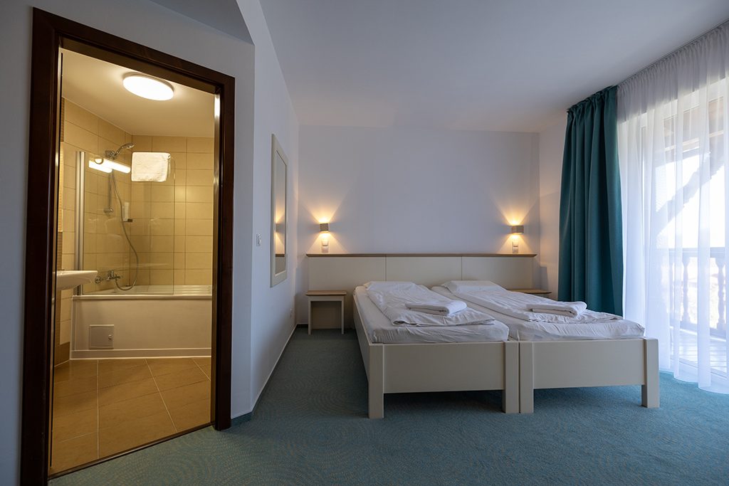 Das Duschbad des Einzelzimmers und die Betten am Fenster
