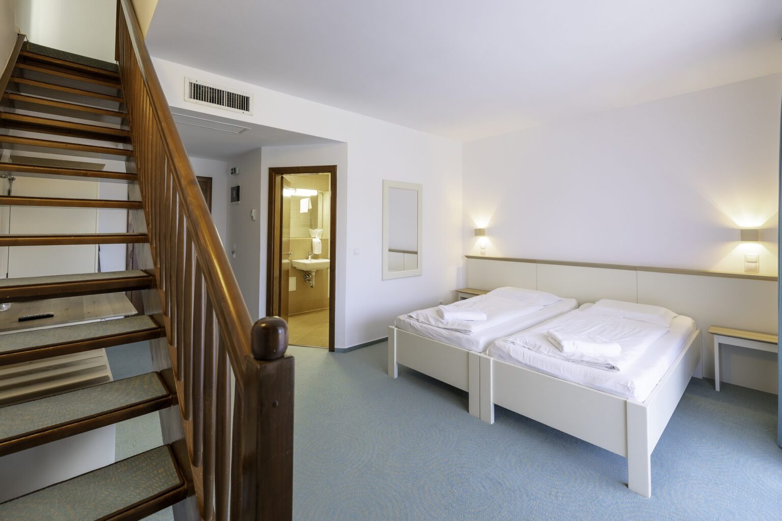 Junior Suite: two single beds next to the wooden staircase