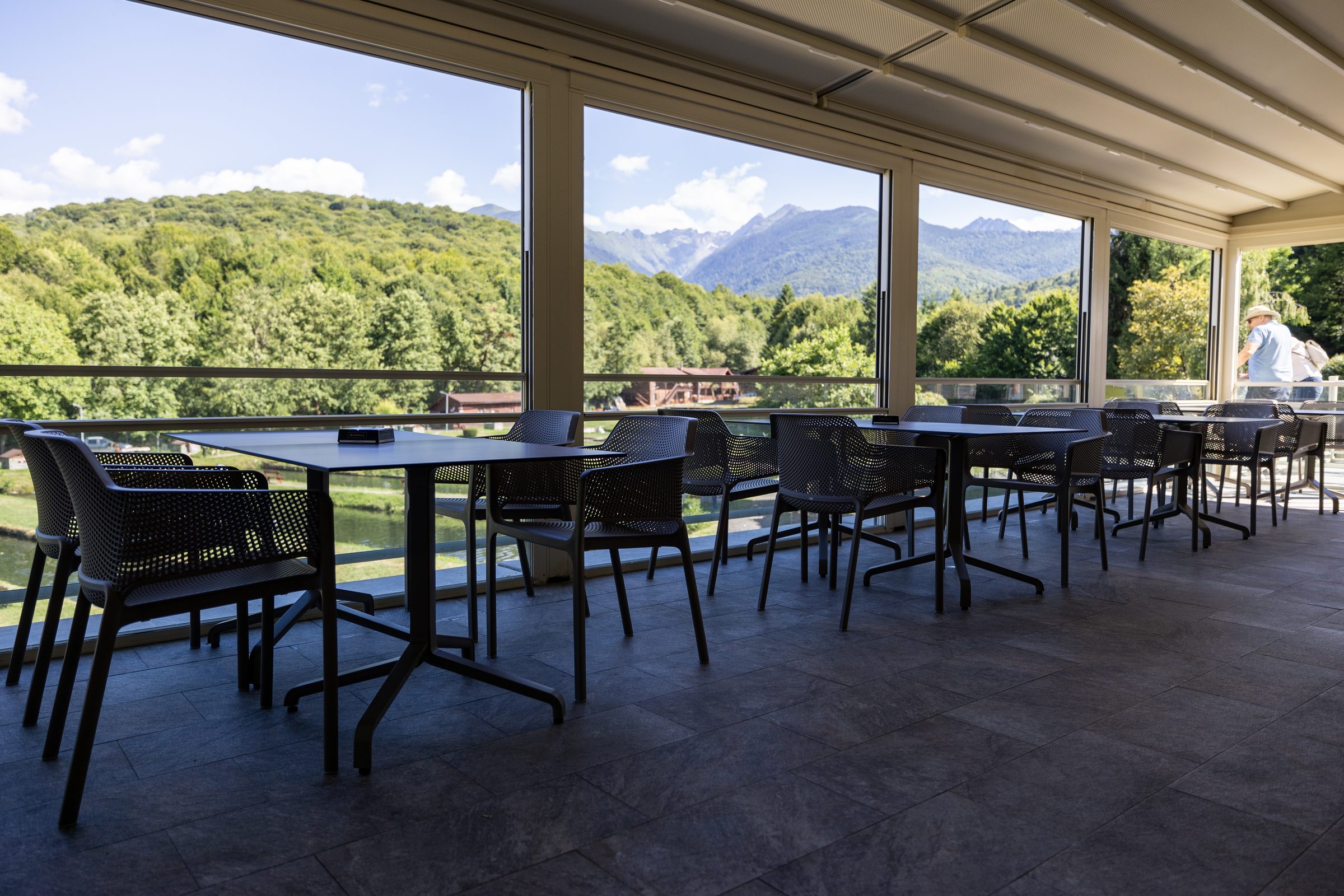 Sala restaurantului cu pereți de sticlă și vedere spre munte